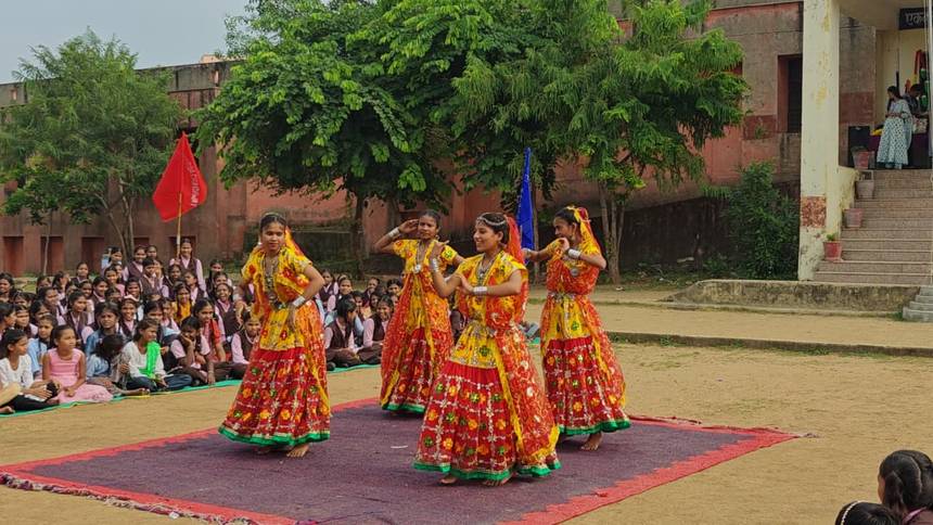 Students performing a folk dance in traditional costume for the school