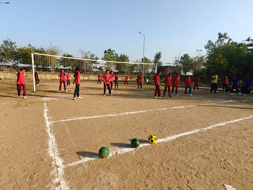 Students playing a volleyball match on the school ground in the afternoon