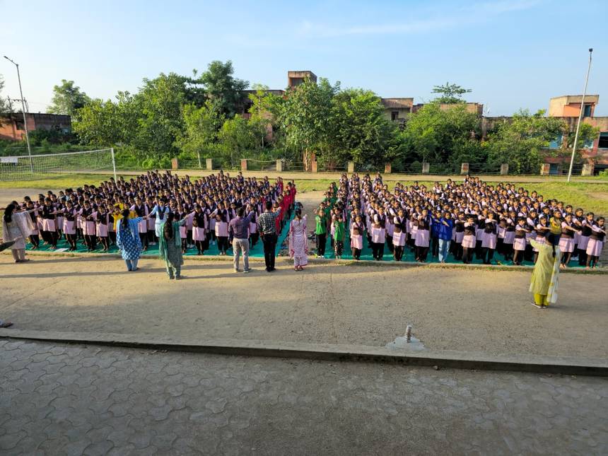 Students performing yoga together on mats during the morning assembly