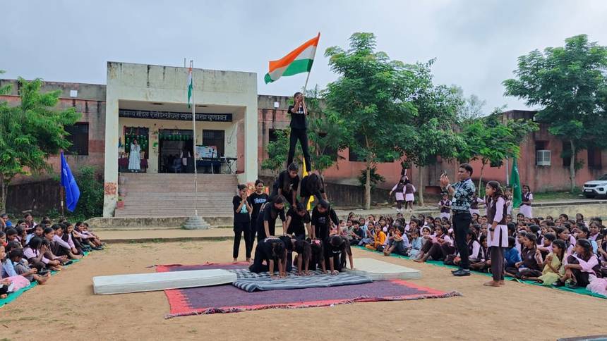 Students forming a human pyramid with the national flag before the assembly