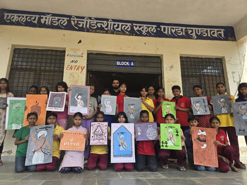 Students displaying their artwork in front of the Block A school building