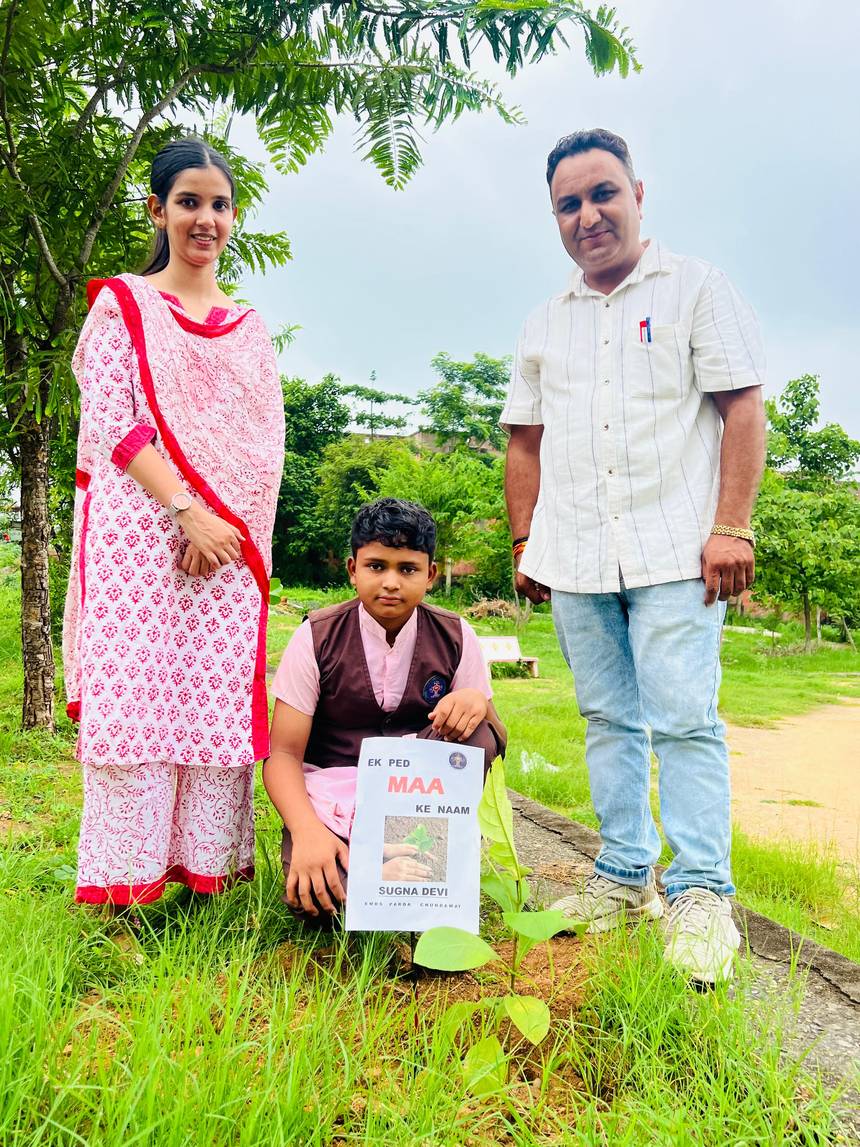 Teachers and a student planting a sapling during the campus plantation drive